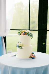 A beautiful white wedding cake with some pastel florals for decoration