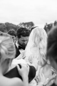 Family and friends surrounding the bride and groom during the ceremony