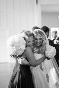 The bride and a bridesmaid hugging after the ceremony